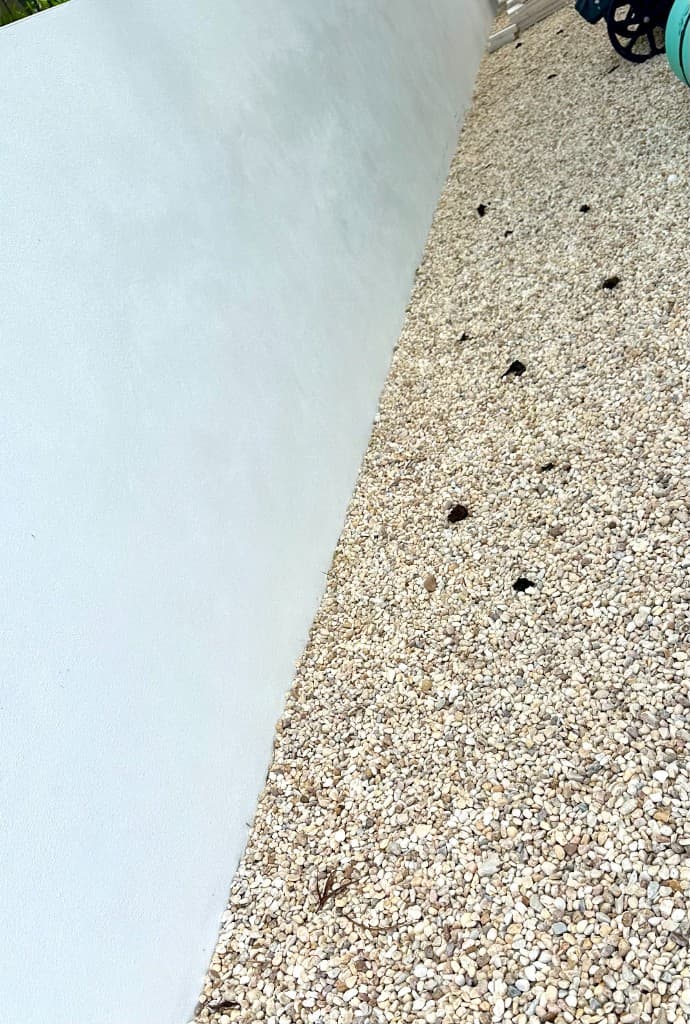Gravel yard before Paradise Poo Rescue pet waste cleanup — waste visible on stones