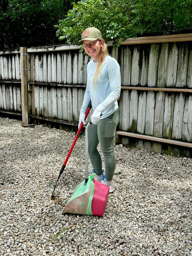 Brittney, Paradise Poo Rescue technician, with professional scooping equipment in a Keys backyard